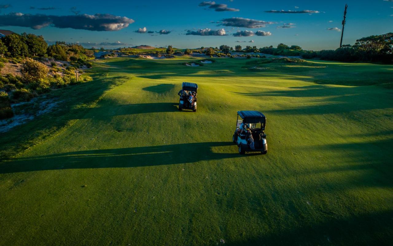 Pullman Magenta Shores Resort Entrance Exterior foto Golf carts on the green